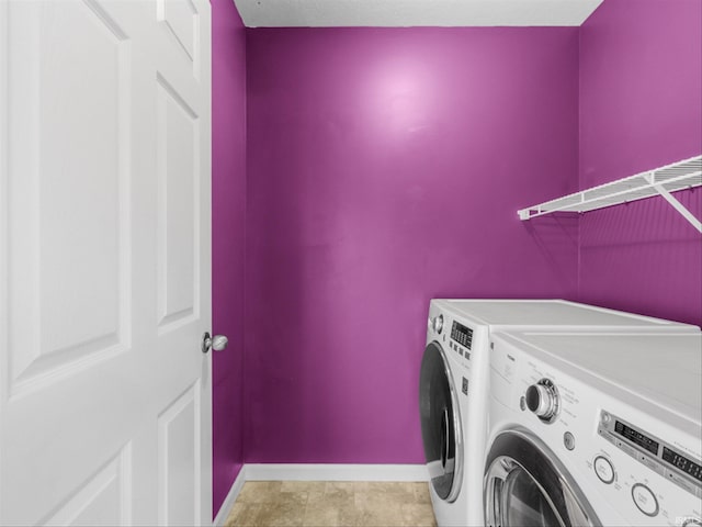 washroom with light tile patterned floors and washer and clothes dryer