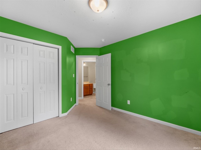 unfurnished bedroom with a closet and light colored carpet