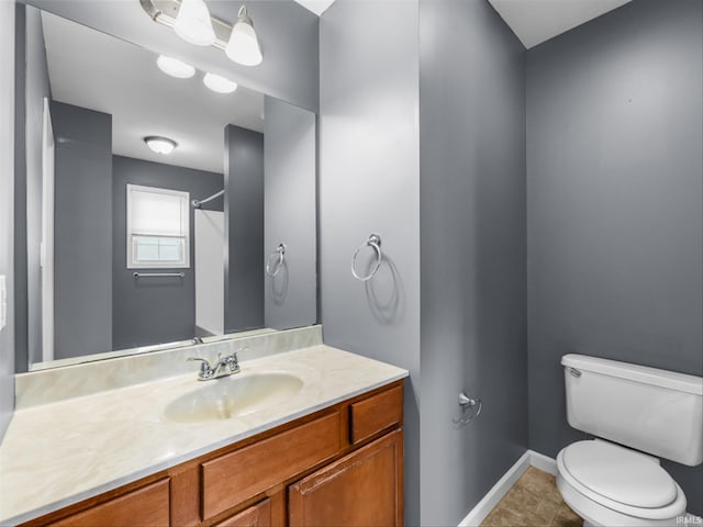 bathroom featuring toilet, vanity, and tile patterned flooring