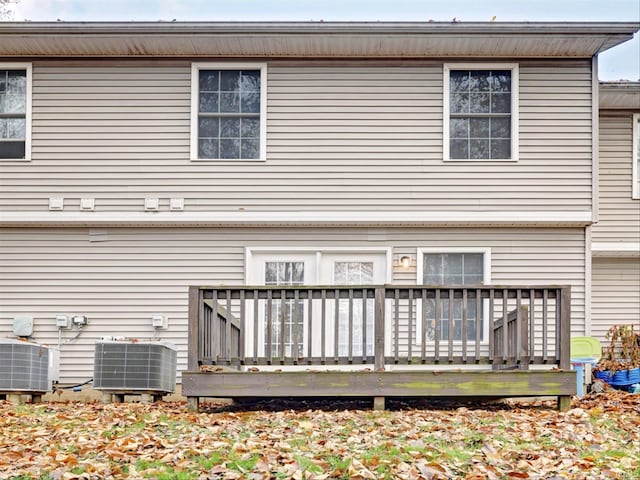 rear view of property featuring a wooden deck and cooling unit