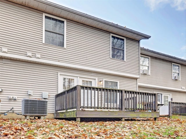 back of property with central air condition unit, a wooden deck, and cooling unit