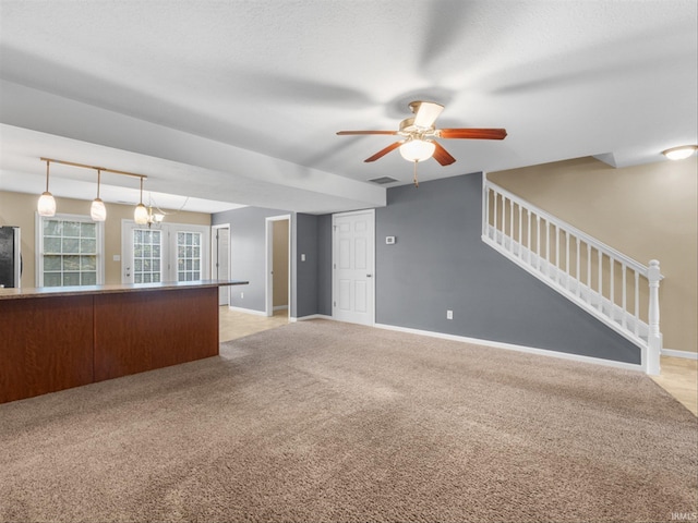 unfurnished living room featuring ceiling fan and light colored carpet