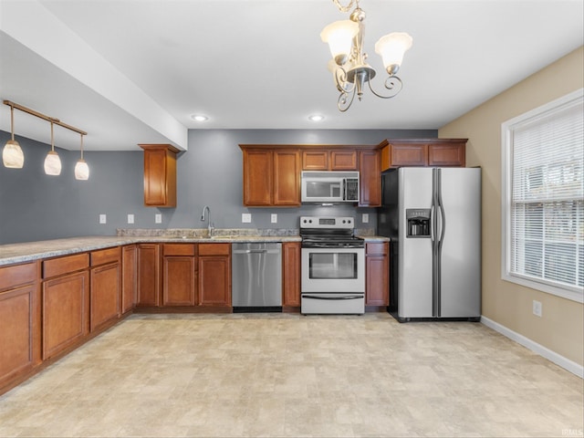 kitchen with pendant lighting, stainless steel appliances, a chandelier, and sink