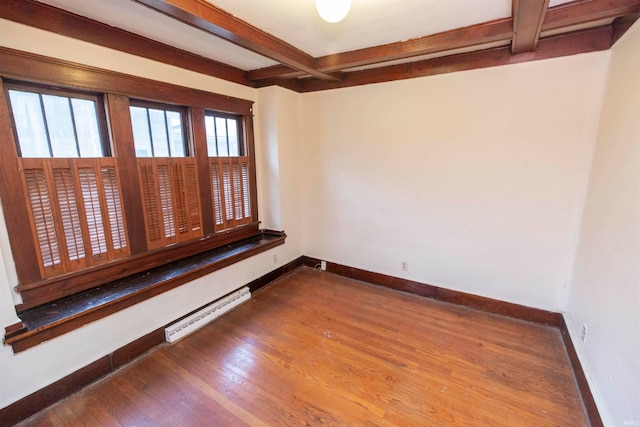 empty room with hardwood / wood-style floors and beamed ceiling