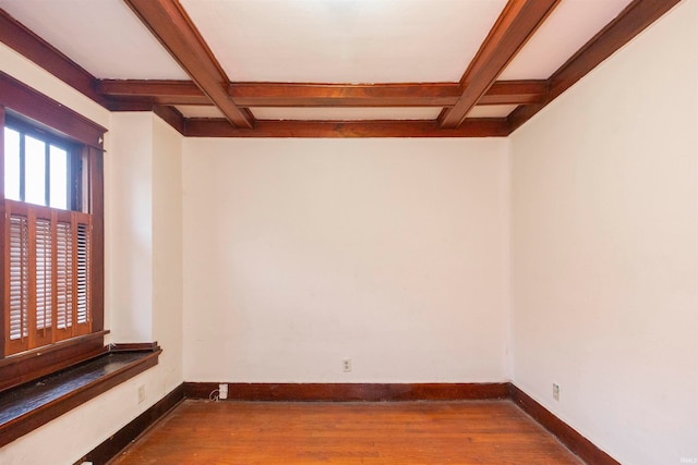 empty room with beamed ceiling, coffered ceiling, and hardwood / wood-style floors