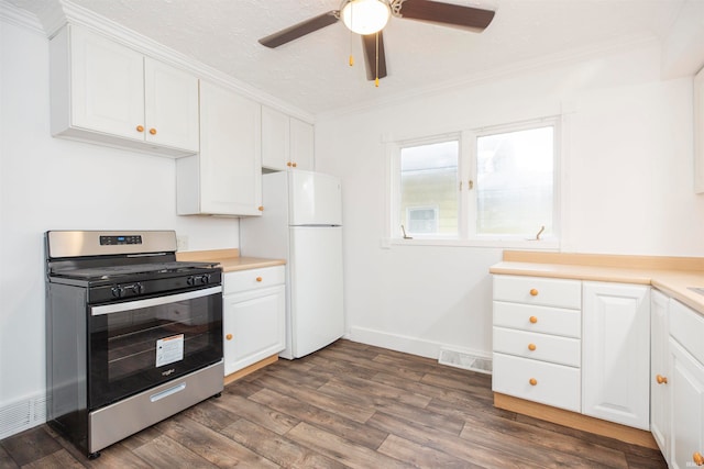 kitchen with gas stove, dark hardwood / wood-style floors, crown molding, white fridge, and white cabinetry