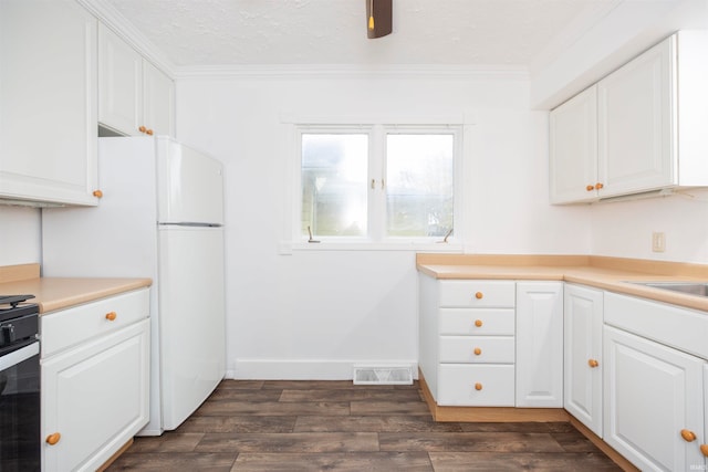 kitchen with white cabinets, a textured ceiling, dark wood-type flooring, and ornamental molding