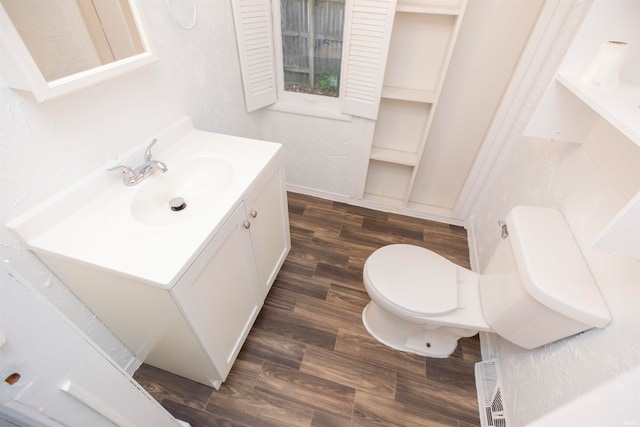 bathroom with wood-type flooring, vanity, and toilet