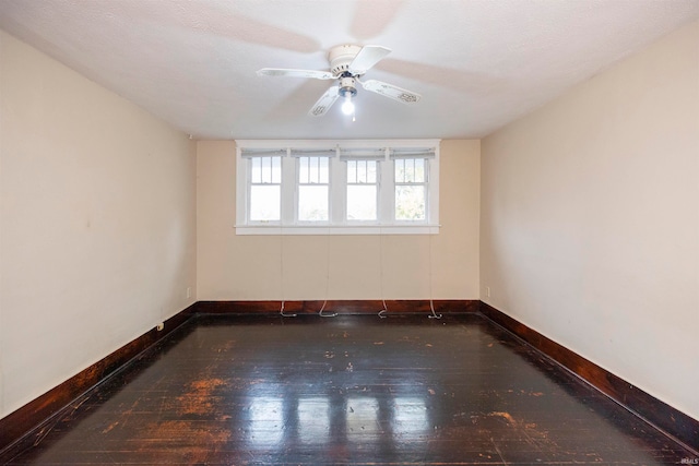 empty room with dark wood-type flooring, ceiling fan, and a textured ceiling