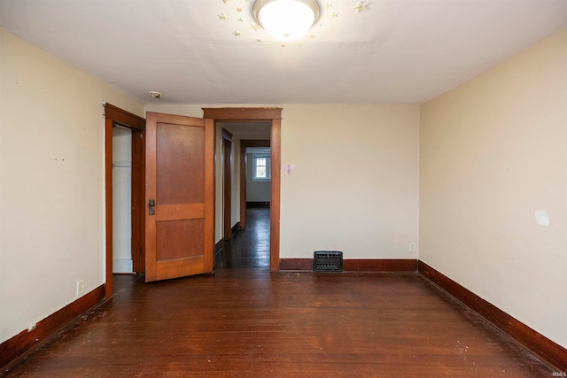 empty room with dark hardwood / wood-style flooring