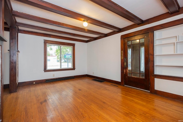 spare room with light hardwood / wood-style floors, baseboard heating, and beam ceiling