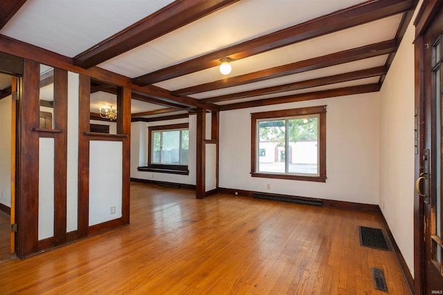 unfurnished room with beamed ceiling, a chandelier, and hardwood / wood-style floors