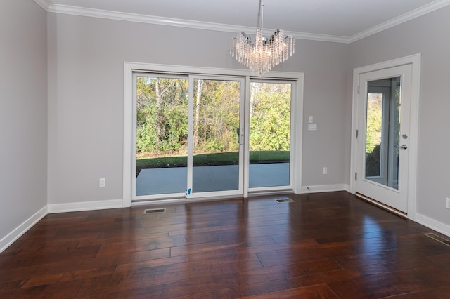 empty room with a notable chandelier, dark hardwood / wood-style flooring, and ornamental molding