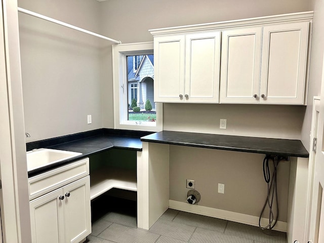 washroom featuring cabinets, electric dryer hookup, light tile patterned floors, and sink