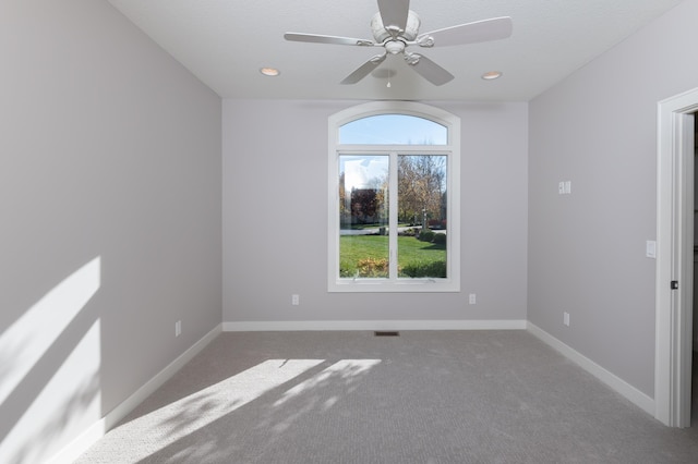 spare room with a textured ceiling, ceiling fan, and carpet floors