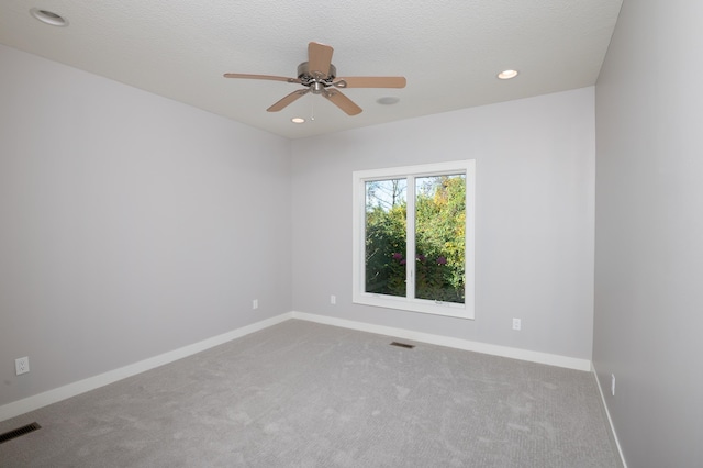 carpeted spare room with a textured ceiling and ceiling fan