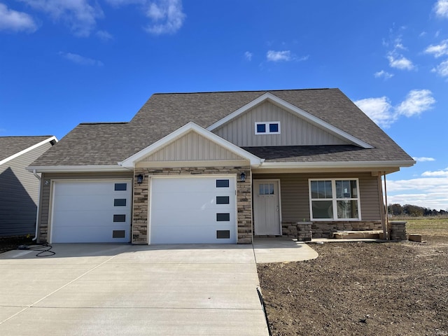 view of front facade with board and batten siding, concrete driveway, a garage, and a shingled roof