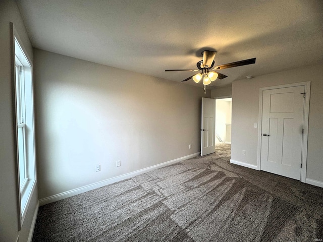 unfurnished bedroom with ceiling fan, a textured ceiling, baseboards, and carpet