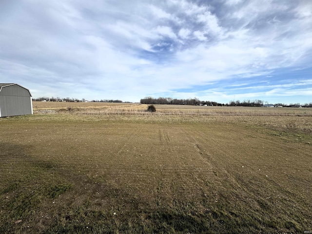 view of yard featuring an outdoor structure and a rural view