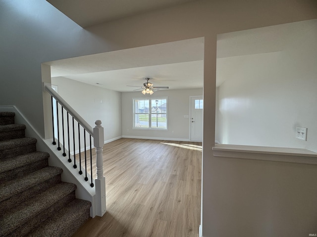 stairway with baseboards, a ceiling fan, and wood finished floors