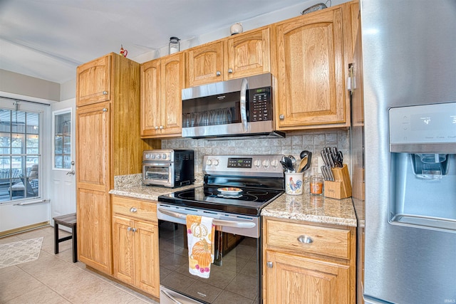 kitchen featuring backsplash, light tile patterned flooring, light stone counters, and stainless steel appliances