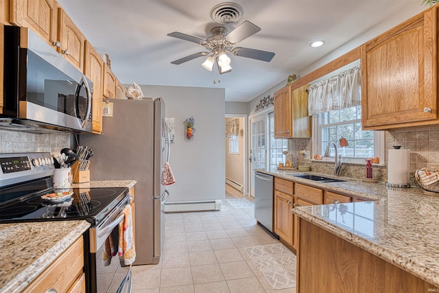 kitchen with backsplash, stainless steel appliances, ceiling fan, baseboard heating, and sink