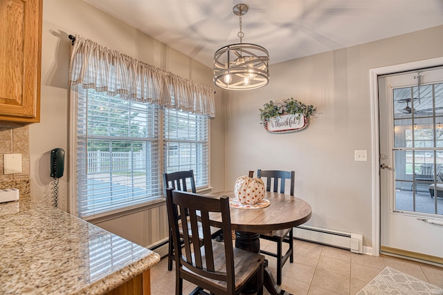 dining area featuring light tile patterned floors, a baseboard radiator, and an inviting chandelier