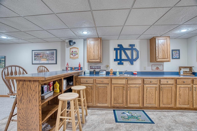 kitchen featuring a paneled ceiling and a breakfast bar area