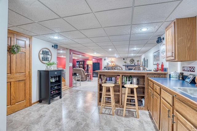 kitchen featuring a breakfast bar area and a drop ceiling