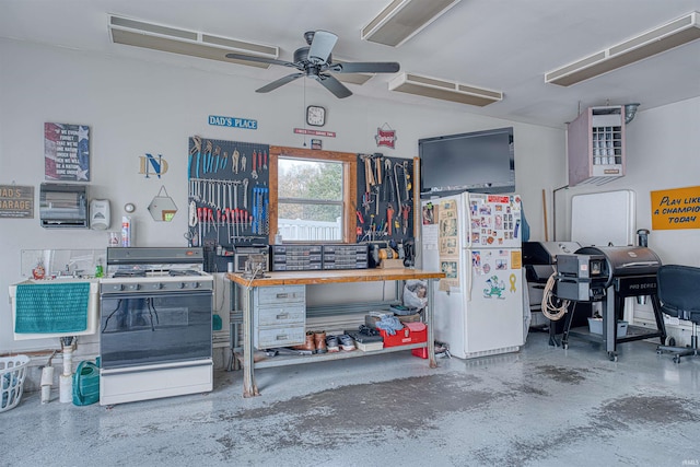 garage featuring white refrigerator, a workshop area, and ceiling fan