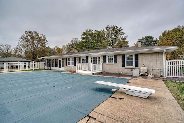 back of house with a patio area and a covered pool