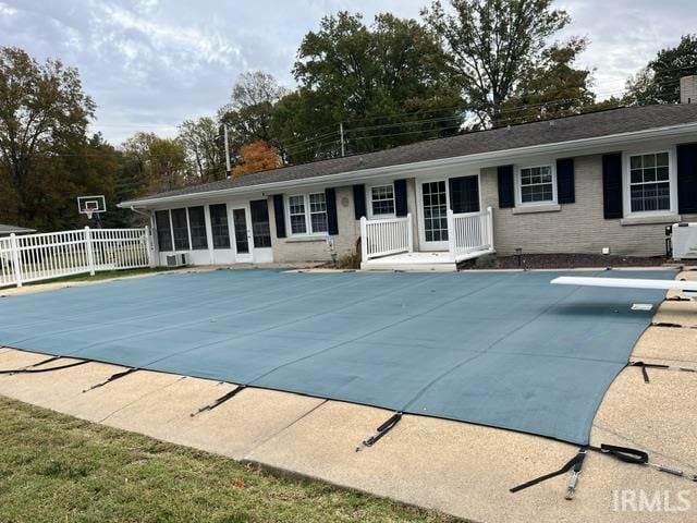 view of pool with a diving board and a patio