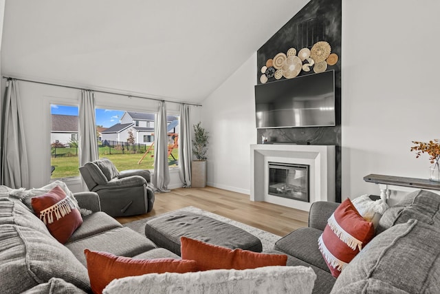 living room with high vaulted ceiling and light wood-type flooring