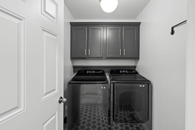 washroom featuring cabinets, a textured ceiling, and separate washer and dryer