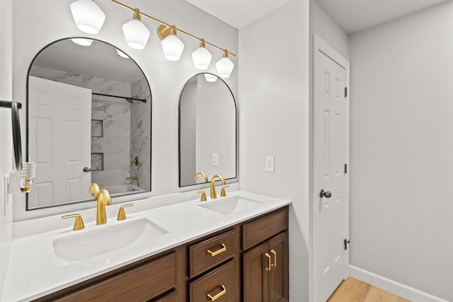 bathroom featuring vanity, tiled shower / bath, and wood-type flooring