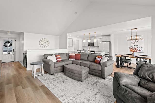 living room featuring high vaulted ceiling and light wood-type flooring