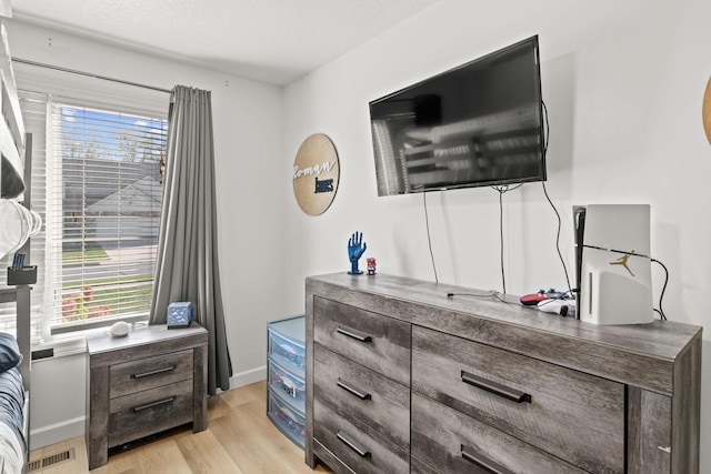 bedroom featuring light hardwood / wood-style flooring and a textured ceiling