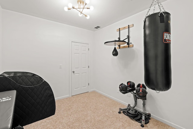 workout room with carpet floors and a chandelier