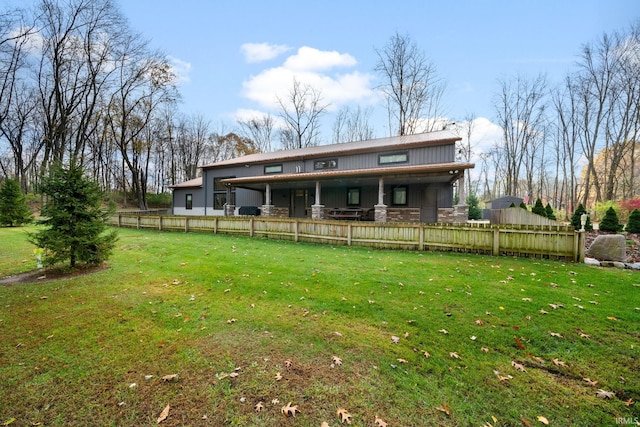 back of property featuring a lawn and covered porch