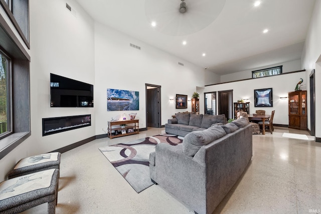 living room with a high ceiling and ceiling fan