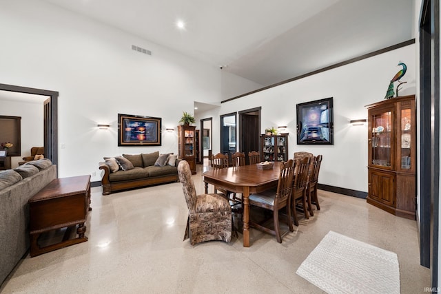 dining room featuring a towering ceiling