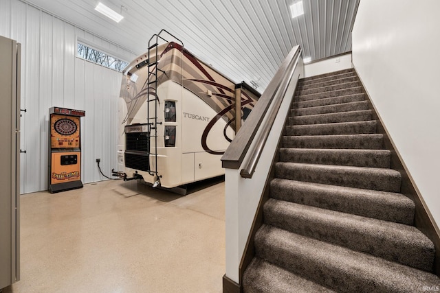 staircase with wooden walls and wood ceiling