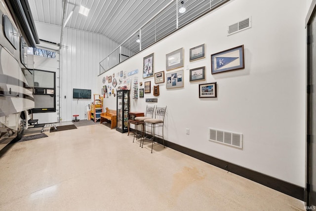 exercise room featuring a towering ceiling