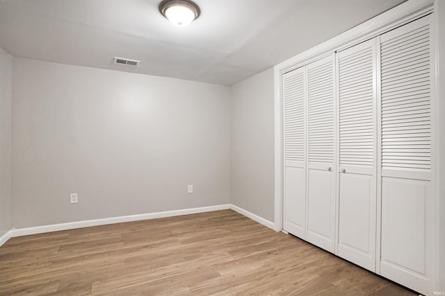 unfurnished bedroom featuring light hardwood / wood-style floors and a closet