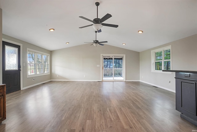 unfurnished living room featuring dark hardwood / wood-style flooring, lofted ceiling, and plenty of natural light