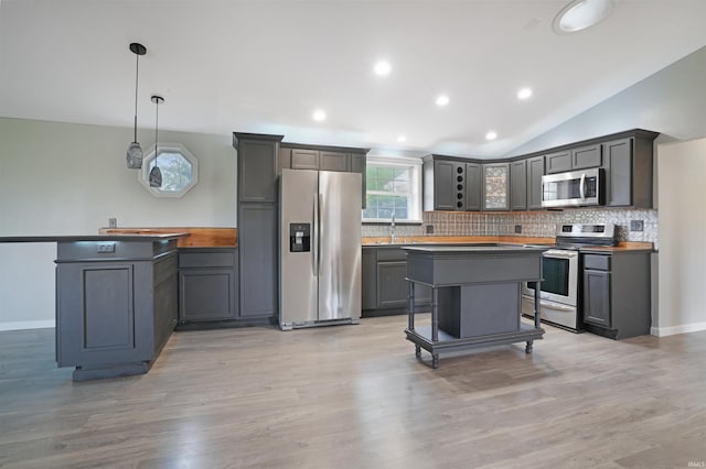 kitchen with gray cabinetry, appliances with stainless steel finishes, decorative light fixtures, and light hardwood / wood-style flooring