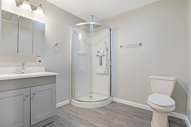 bathroom with hardwood / wood-style flooring, vanity, toilet, and an enclosed shower