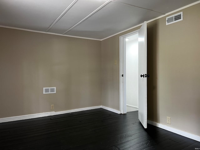 empty room with dark hardwood / wood-style flooring and crown molding