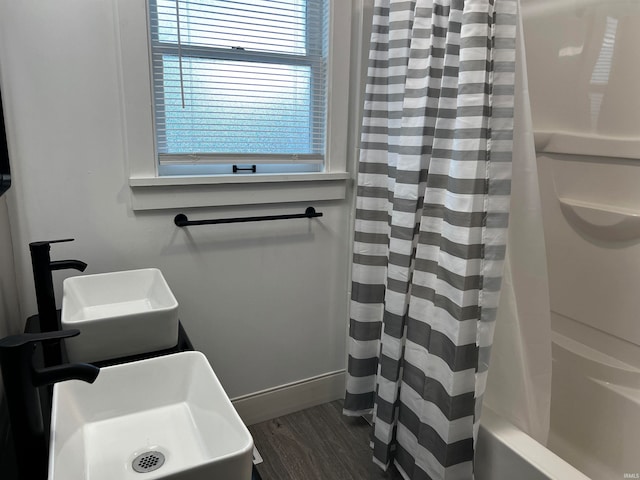 bathroom with shower / bath combo with shower curtain and wood-type flooring