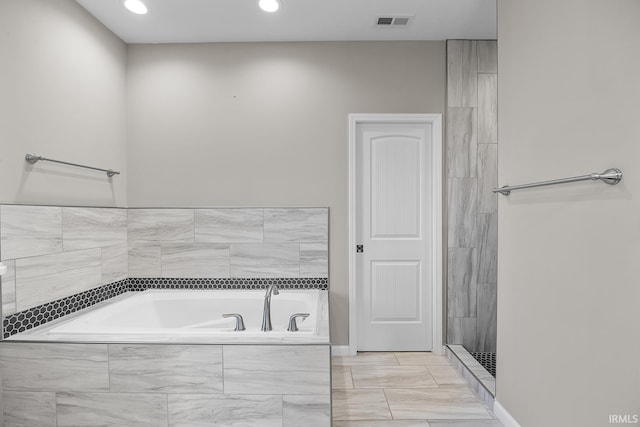 bathroom featuring a relaxing tiled tub